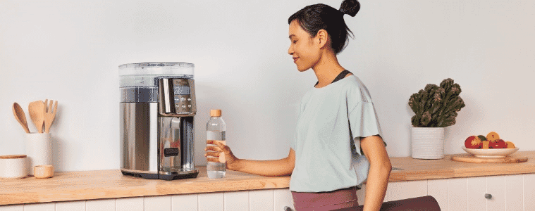 A woman uses a Breville AquaStation Chilled + Hot