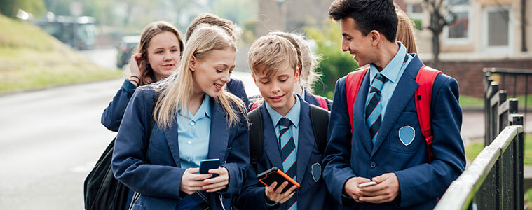 A group of teenage students walking home from school together in uniform