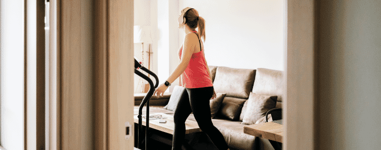 Woman exercises on a treadmill in her living room