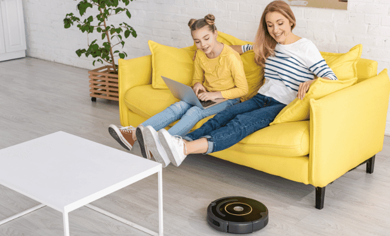 Mother and daughter relax as a robot vacuum cleans the house