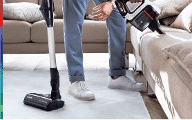 Man cleaning couch with Bosch Vacuum. 