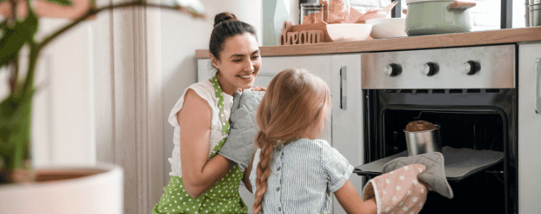 a mother and daughter cooking a cake together in an oven 