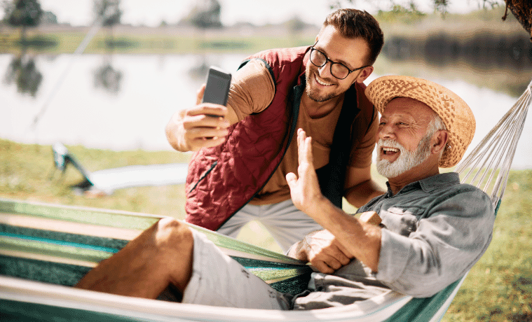 A Man And His Dad Facetiming Family While Laying In A Hammock