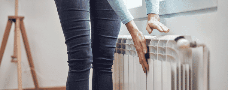 a woman standing next to a gas heater 