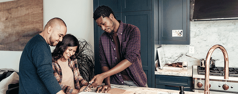 A husband and wife look at swatches, with the help of a kitchen designer, when planning a new kitchen.