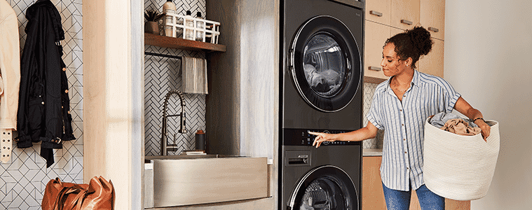 A woman prepares to remove a load from the dryer section of the LG WashTower.