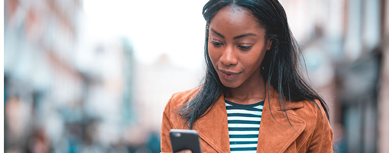 Close-up of a woman holding a smartphone in her hands, checking a text or email.