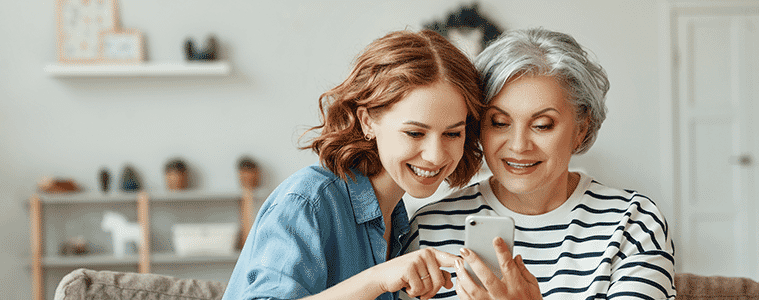 a mum and daughter looking at their mobile phone 