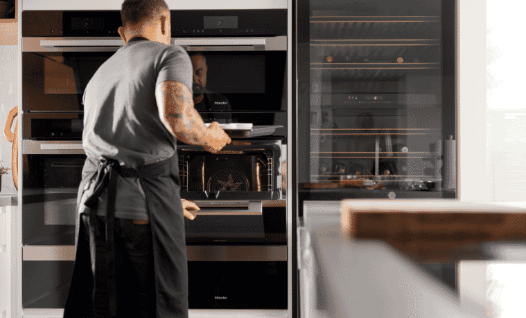 A man putting food into a Miele oven 