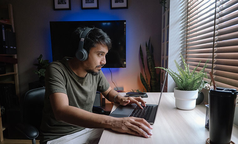 Man playing a computer game on his laptop at home