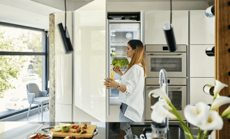 Woman in a modern kitchen opening the fridge.