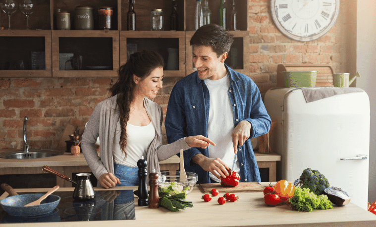 a man and woman cooking together in the kitchen