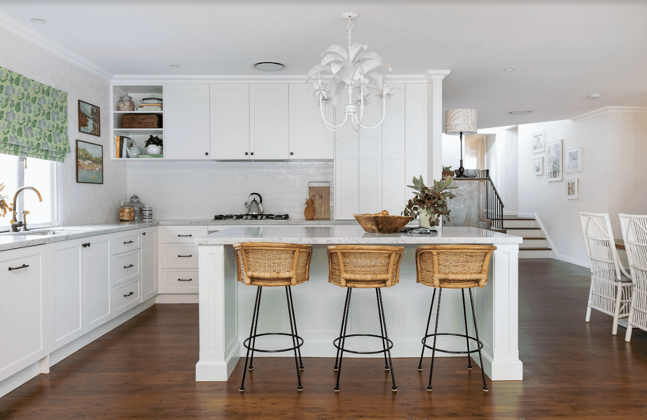 White Hamptons-style kitchen with cane breakfast stools.