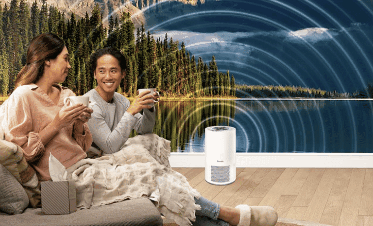 a man and a woman sitting on the couch drinking tea with their Breville Air Purifier producing clean fresh air 