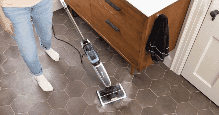 Image of a woman using the Shark Steam Pickup 3-in-1 Steam Mop to clean tiles.