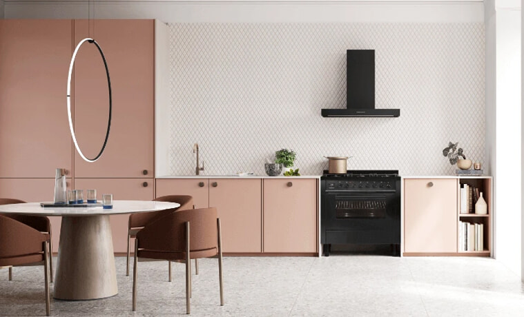 A light and airy pink kitchen with black appliances.